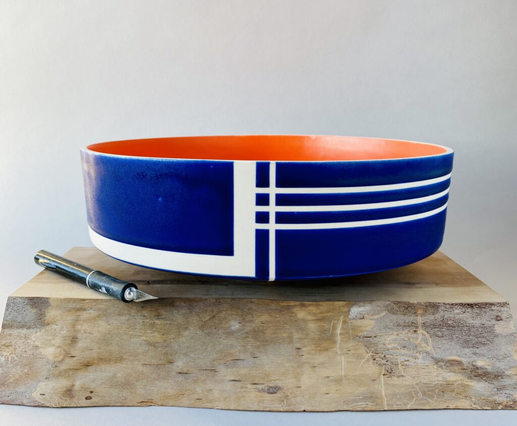 Cobalt blue bowl with orange interior and white inlaid lines
