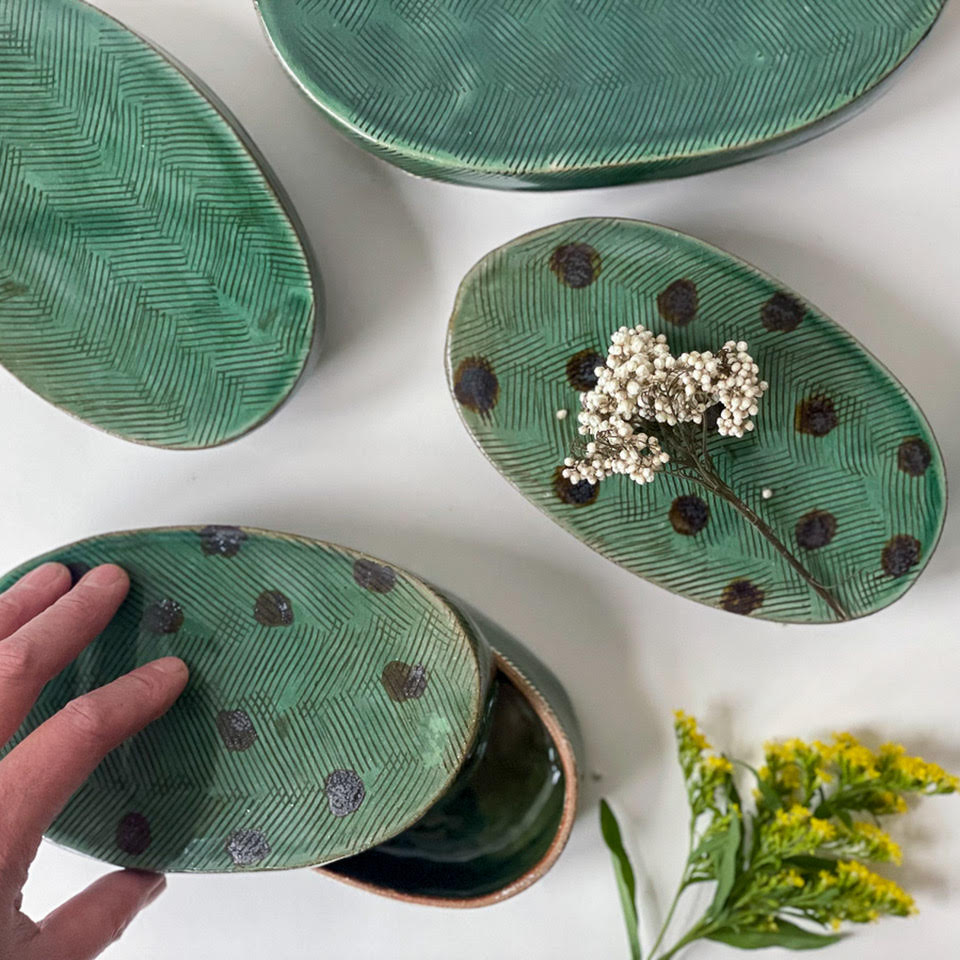 Green textured oval dishes with dark spots